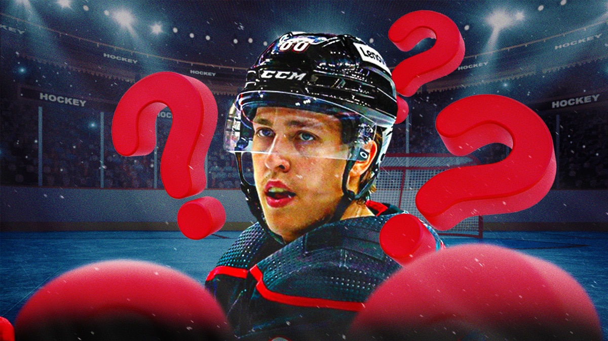 Teuvo Teravainen in middle of image looking stern, 3-5 question marks, hockey rink in background