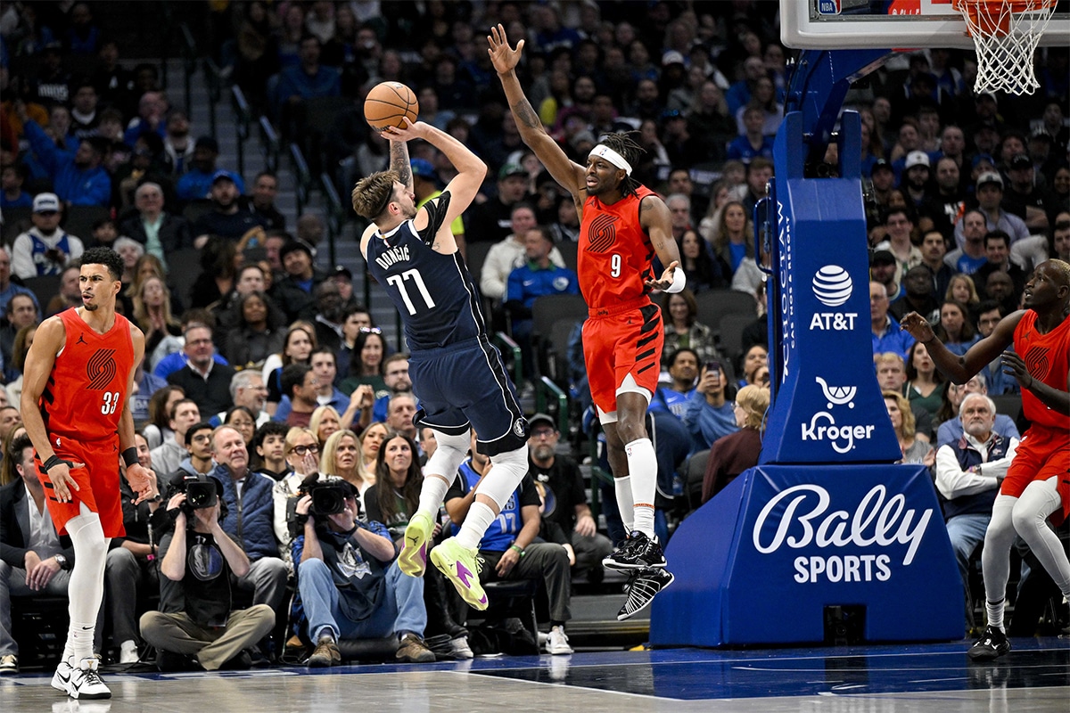 Dallas Mavericks guard Luka Doncic (77) shoots over Portland Trail Blazers forward Jerami Grant (9) during the first quarter at the American Airlines Center. 