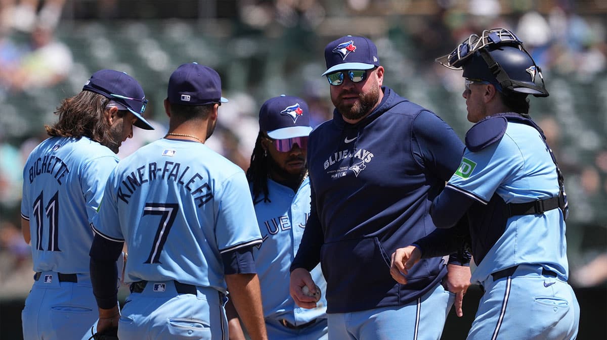 Toronto Blue Jays manager John Schneider (second from right) talks with players during a pitching change in the seventh inning against the Oakland Athletics at Oakland-Alameda County Coliseum