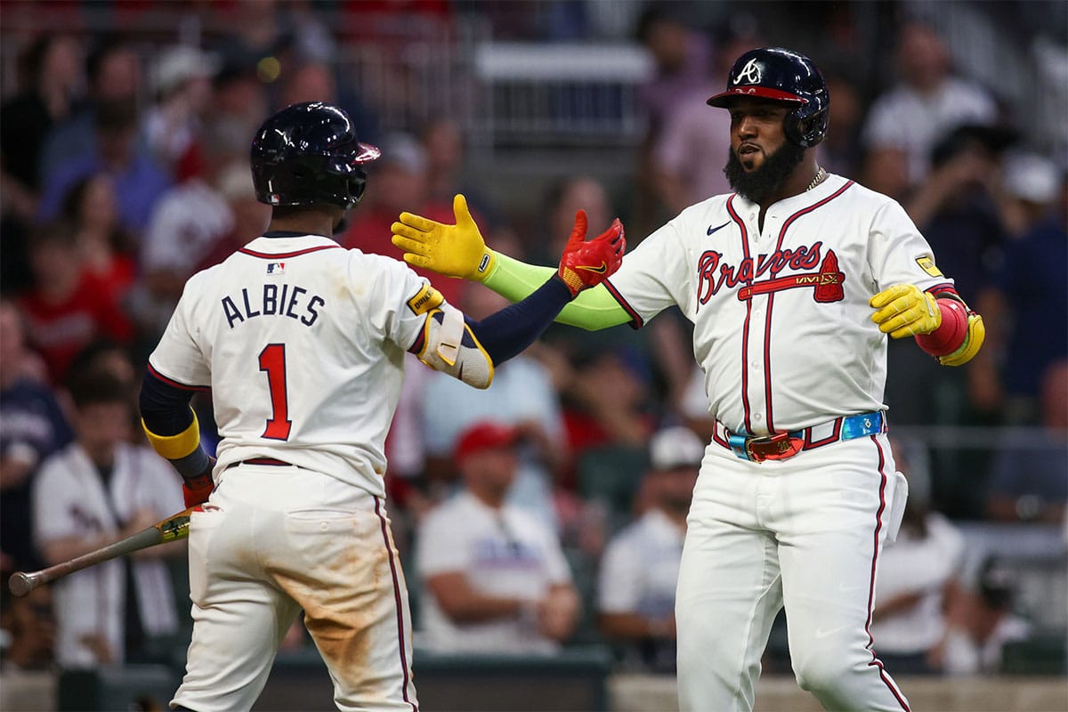Atlanta Braves designated hitter Marcell Ozuna (20) celebrates after a home run with second baseman Ozzie Albies (1) against the Washington Nationals in the seventh inning at Truist Park.