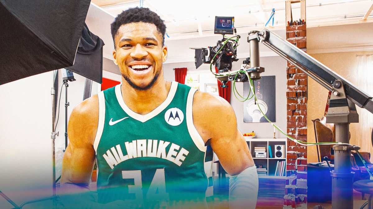 Bucks' Giannis Antetokounmpo smiling, with a film set beside him