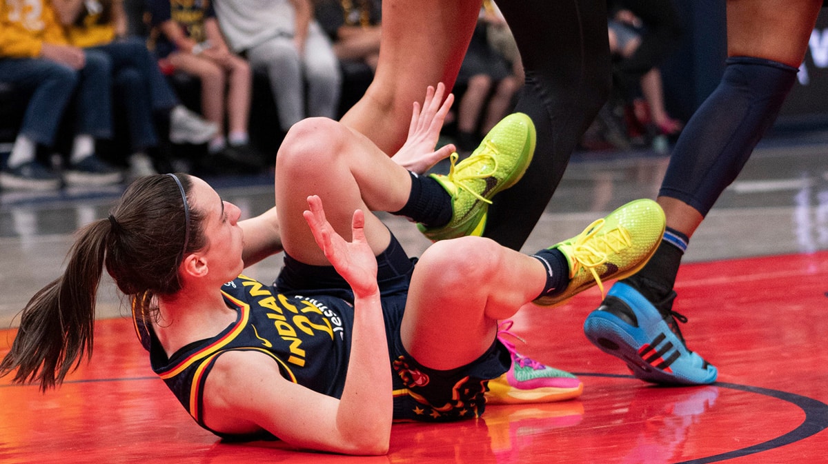 Indiana Fever guard Caitlin Clark (22) attempts to get up as Chicago Sky center Camilla Cardoso (10) runs around her