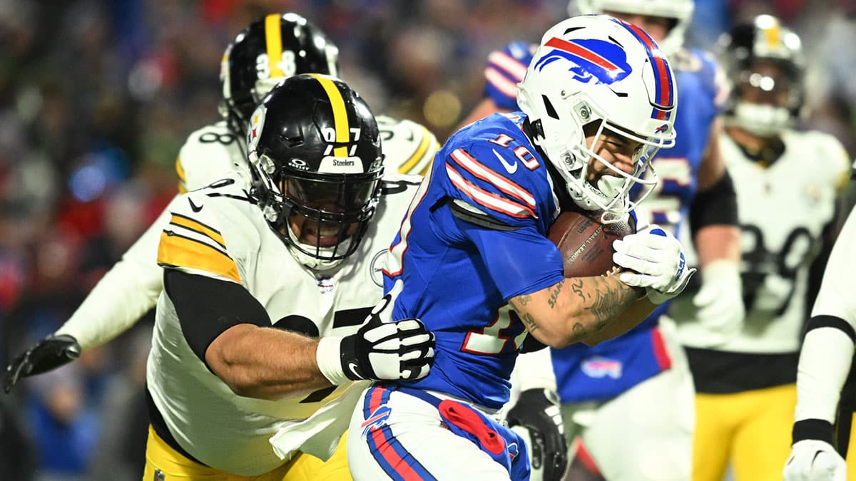 Buffalo Bills wide receiver Khalil Shakir (10) runs the ball pressured by Pittsburgh Steelers defensive tackle Cameron Heyward (97) in a 2024 AFC wild card game at Highmark Stadium.