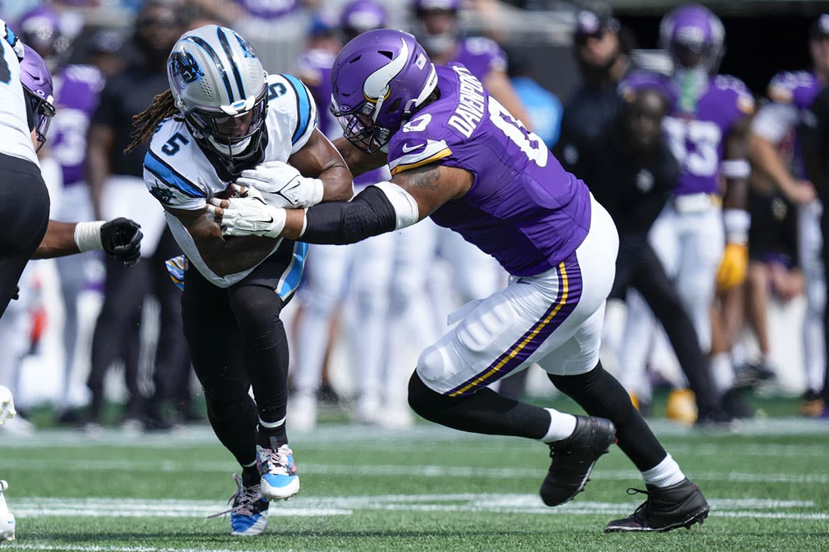 Carolina Panthers place kicker Eddy Pineiro (4) is tackled by Minnesota Vikings linebacker Marcus Davenport (0) during the second half at Bank of America Stadium. 