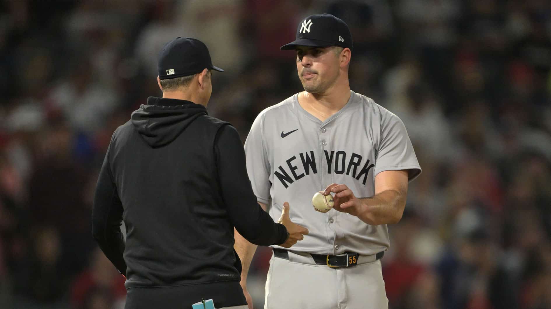 New York Yankees manager Aaron Boone (17) takes the ball from starting pitcher Carlos Rodon (55) as he leaves the game in the seventh inning against the Los Angeles Angels at Angel Stadium.