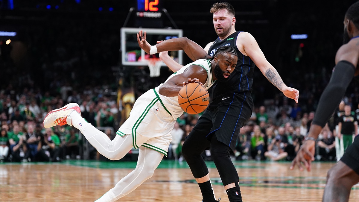 Celtics guard Jaylen Brown (7) controls the ball against Dallas Mavericks guard Luka Doncic (77)