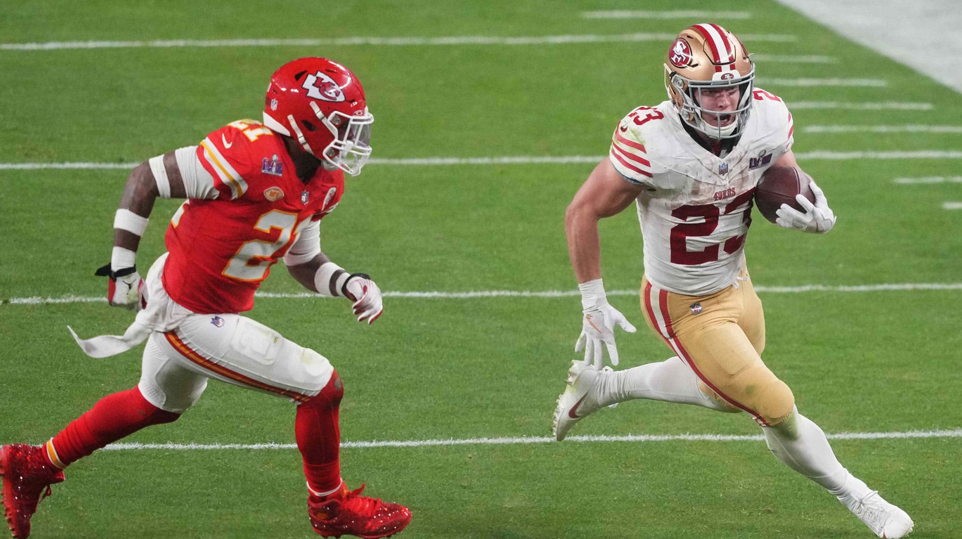 San Francisco 49ers running back Christian McCaffrey (23) runs with the ball against Kansas City Chiefs safety Mike Edwards (21) during overtime of Super Bowl LVIII at Allegiant Stadium.