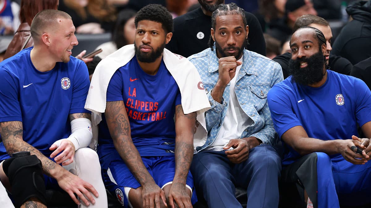 Clippers center Daniel Theis (10, left) and forward Paul George (13) and forward Kawhi Leonard (2) and guard James Harden (1, right) watch the game from the bench
