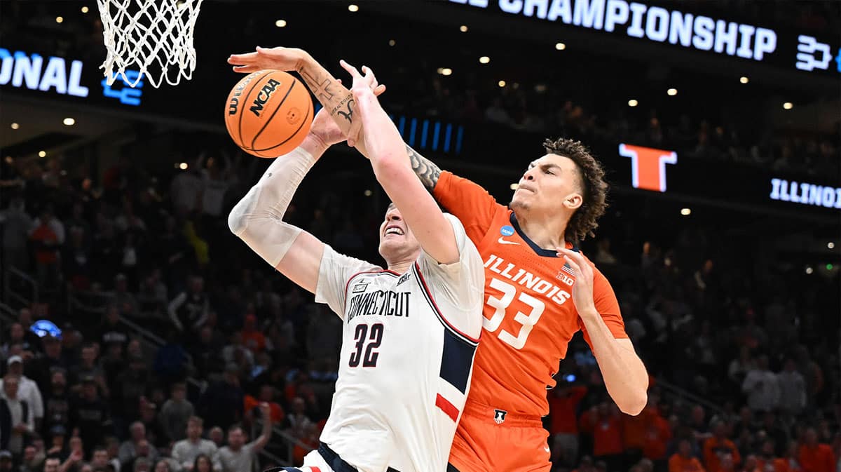 Connecticut Huskies guard Cam Spencer (12) shoots the ball on Illinois Fighting Illini forward Coleman Hawkins (33) in the finals of the East Regional of the 2024 NCAA Tournament at TD Garden. 