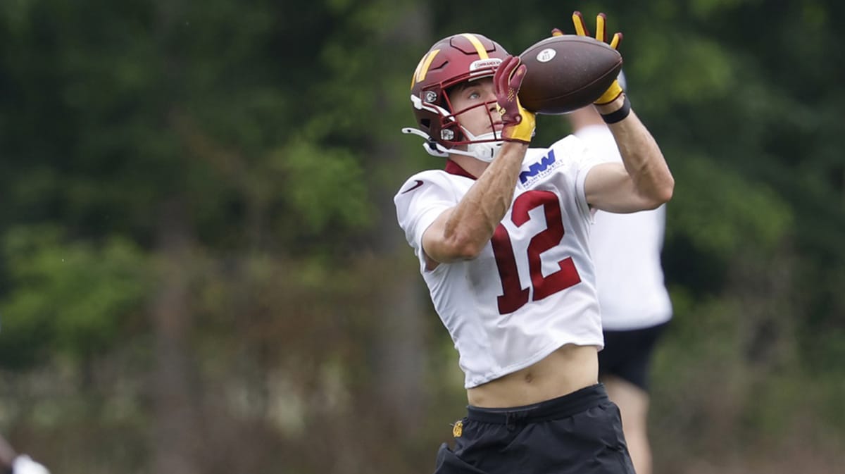 Washington Commanders wide receiver Luke McCaffrey (12) catches a pass during an OTA workout at Commanders Park. 