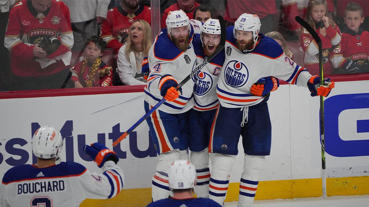 Edmonton Oilers forward Connor McDavid (97) celebrates scoring an empty net goal with defenseman Mattias Ekholm (14) and forward Adam Henrique (19) during the third period against the Florida Panthers in game five of the 2024 Stanley Cup Final at Amerant Bank Arena.