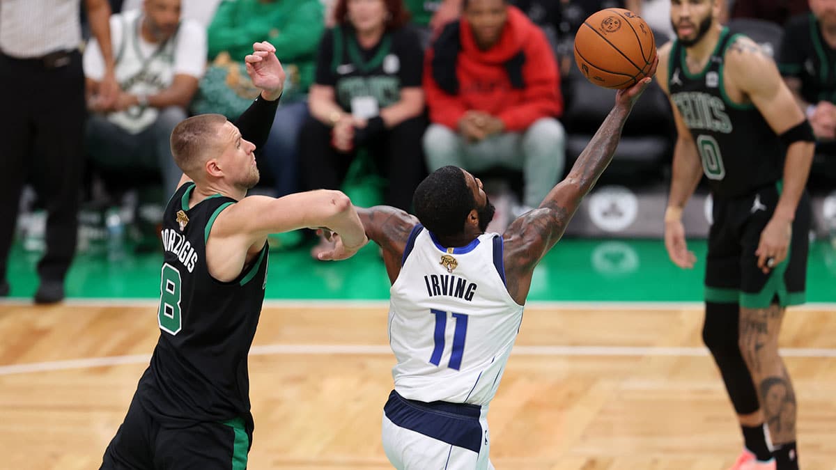 Jun 9, 2024; Boston, Massachusetts, USA; Dallas Mavericks guard Kyrie Irving (11) shoots the ball against Boston Celtics center Kristaps Porzingis (8) during the fourth quarter in game two of the 2024 NBA Finals at TD Garden. Mandatory Credit: Peter Casey-USA TODAY Sports