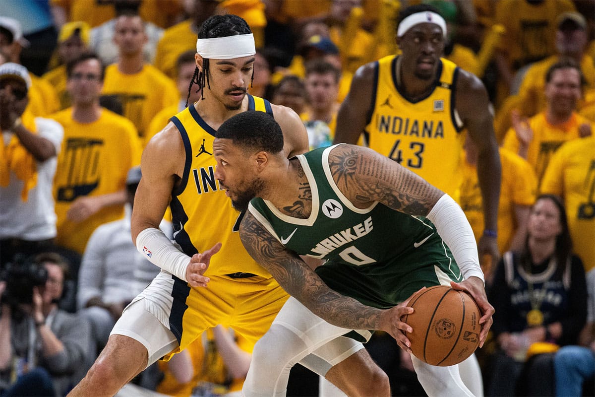 Milwaukee Bucks guard Damian Lillard (0) holds the ball while Indiana Pacers guard Andrew Nembhard (2) defends during game six of the first round for the 2024 NBA playoffs at Gainbridge Fieldhouse. 