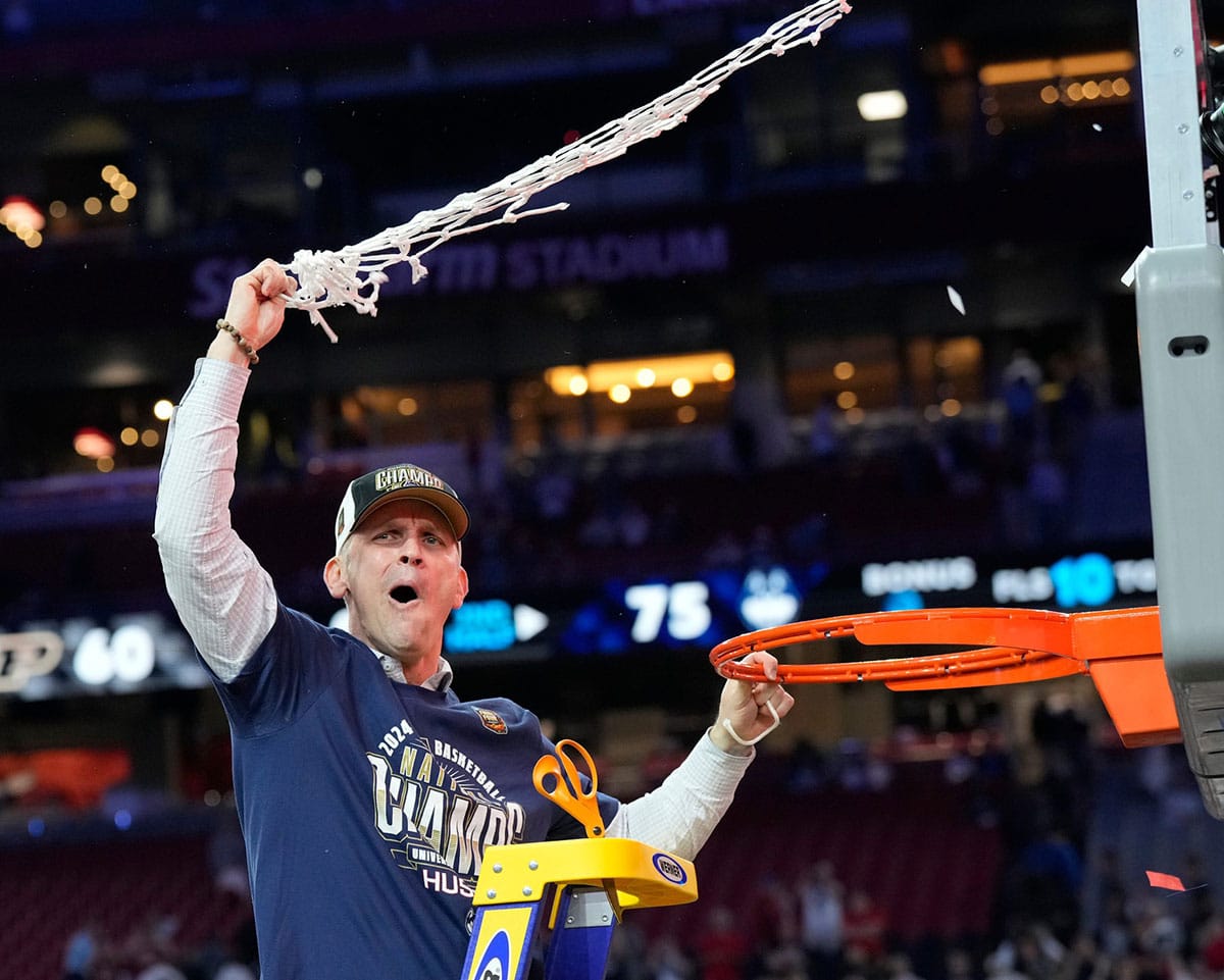 Connecticut Huskies head coach Dan Hurley cuts the basketball net winning the Men's NCAA national championship game against the Purdue Boilermakers 
