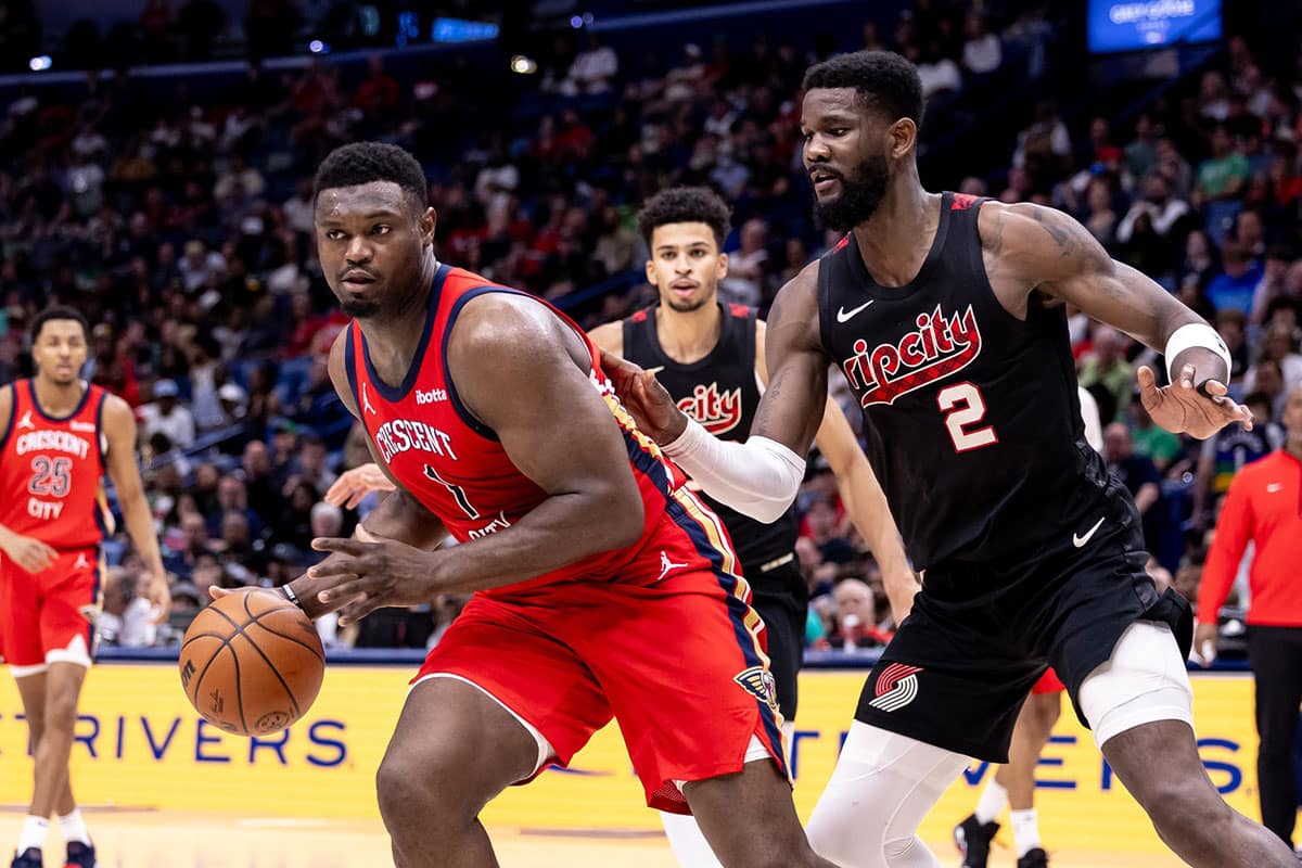 New Orleans Pelicans forward Zion Williamson (1) dribbles against Portland Trail Blazers center Deandre Ayton (2) during the second half at Smoothie King Center.