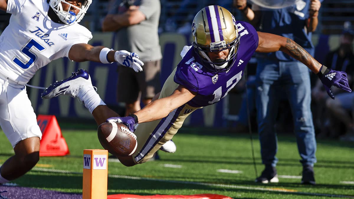 Washington Huskies wide receiver Denzel Boston (12) attempts to score a touchdown against Tulsa Golden Hurricane defensive back Keuan Parker (5) during the fourth quarter at Alaska Airlines Field at Husky Stadium. Boston went out of bounds at the two-yard line.