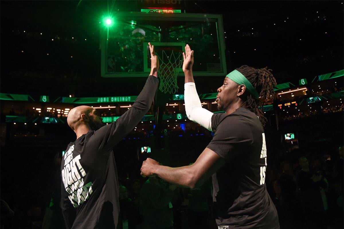 Boston Celtics guard Derrick White (9) high fives guard Jrue Holiday (4) prior to the start of a game against the Houston Rockets at TD Garden.
