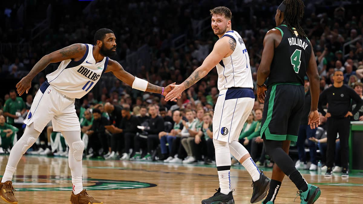 Dallas Mavericks guard Kyrie Irving (11) high fives guard Luka Doncic (77) after a play against the Boston Celtics during the first quarter in game two of the 2024 NBA Finals at TD Garden.