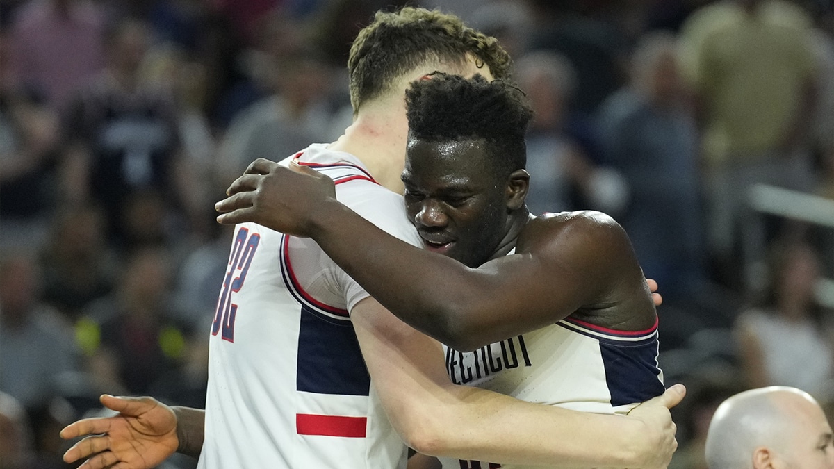Connecticut Huskies forward Adama Sanogo (21) and Connecticut Huskies center Donovan Clingan (32) hug in the semifinals of the Final Four of the 2023 NCAA Tournament against the Miami Hurricanes at NRG Stadium