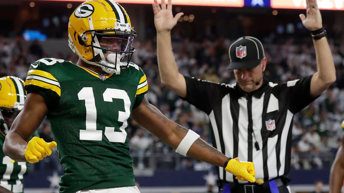Green Bay Packers wide receiver Dontayvion Wicks (13) celebrates after catching a touchdown pass against Dallas Cowboys linebacker Micah Parsons (11) during the second quarter of their wild card playoff game Sunday, January 14, 2024 at AT&T Stadium in Arlington, Texas.