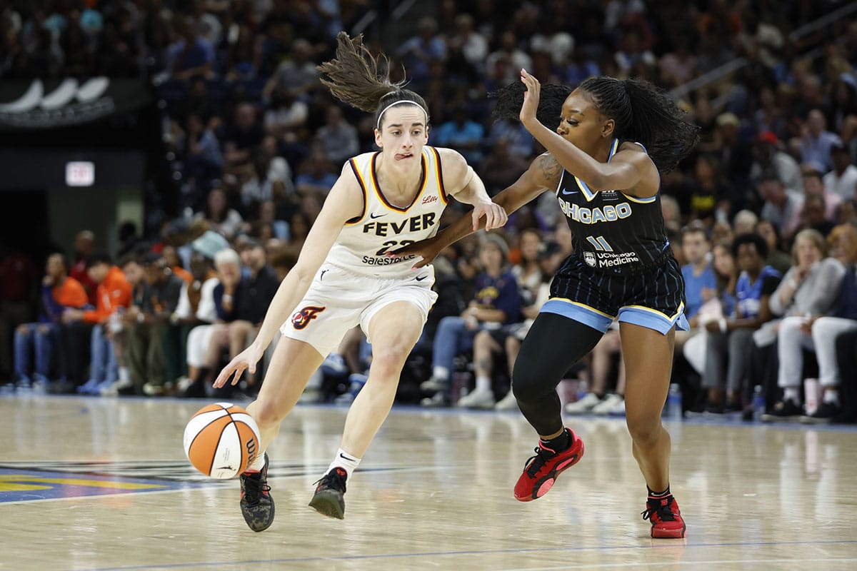 Indiana Fever guard Caitlin Clark (22) drives to the basket against Chicago Sky guard Dana Evans (11) during the first half of a basketball game at Wintrust Arena.