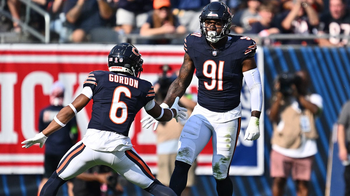 Chicago Bears defensive lineman Yannick Ngakoue (91) celebrates with defensive back Kyler Gordon (6) after dropping the Green Bay Packers ballcarrier for a loss in the first half at Soldier Field.