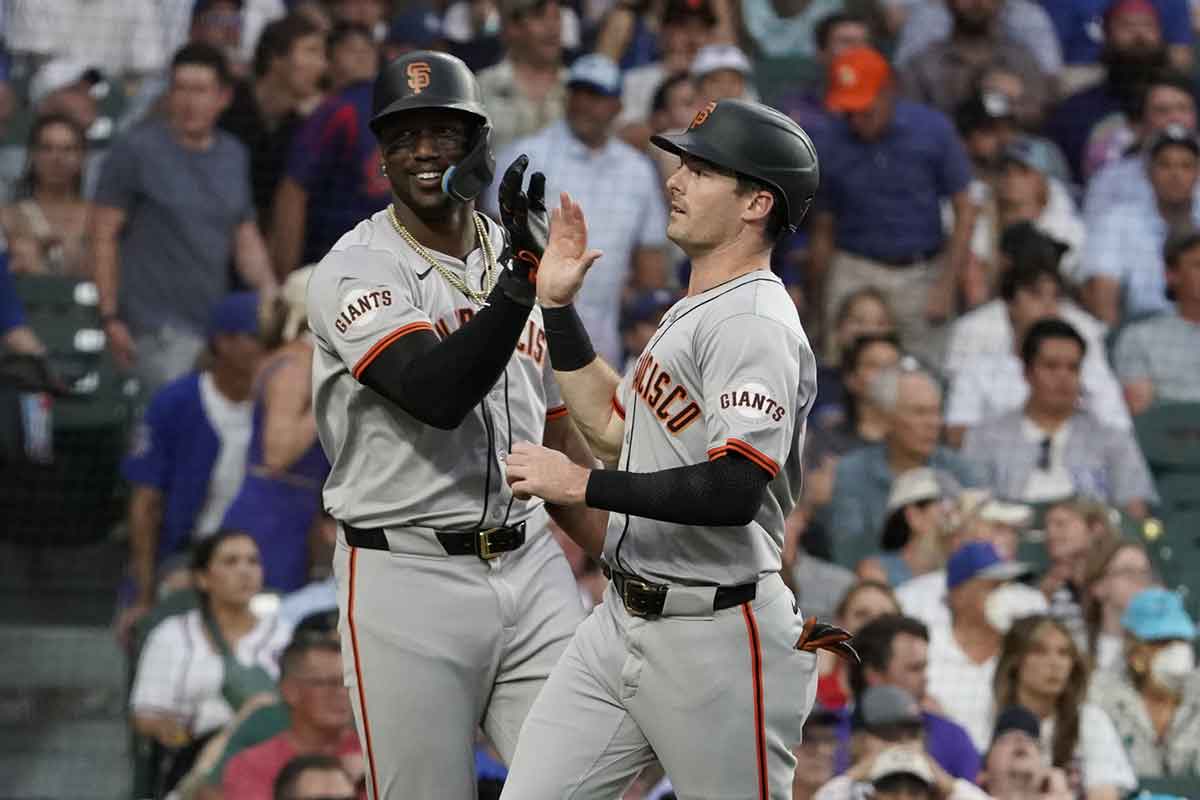 an Francisco Giants outfielder Mike Yastrzemski (right) is greeted by designated hitter Jorge Soler (left) after scoring against the Chicago Cubs during the fifth inning at Wrigley Field.