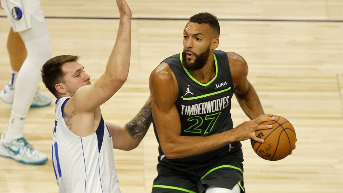 Minnesota Timberwolves center Rudy Gobert (27) looks to pass against Dallas Mavericks guard Luka Doncic (77) during the first quarter in game five of the western conference finals for the 2024 NBA playoffs at Target Center.