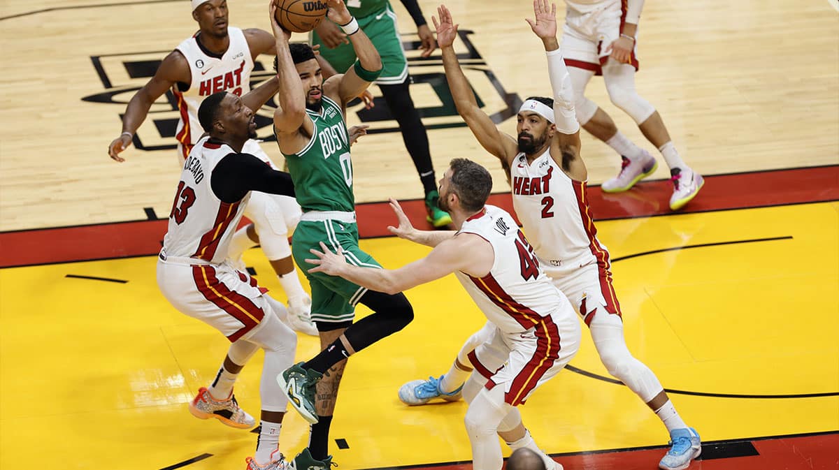 Boston Celtics forward Jayson Tatum (0) controls the ball against Miami Heat center Bam Adebayo (13) and forward Kevin Love (42) and guard Gabe Vincent (2) in the first quarter during game four of the Eastern Conference Finals for the 2023 NBA playoffs at Kaseya Center.
