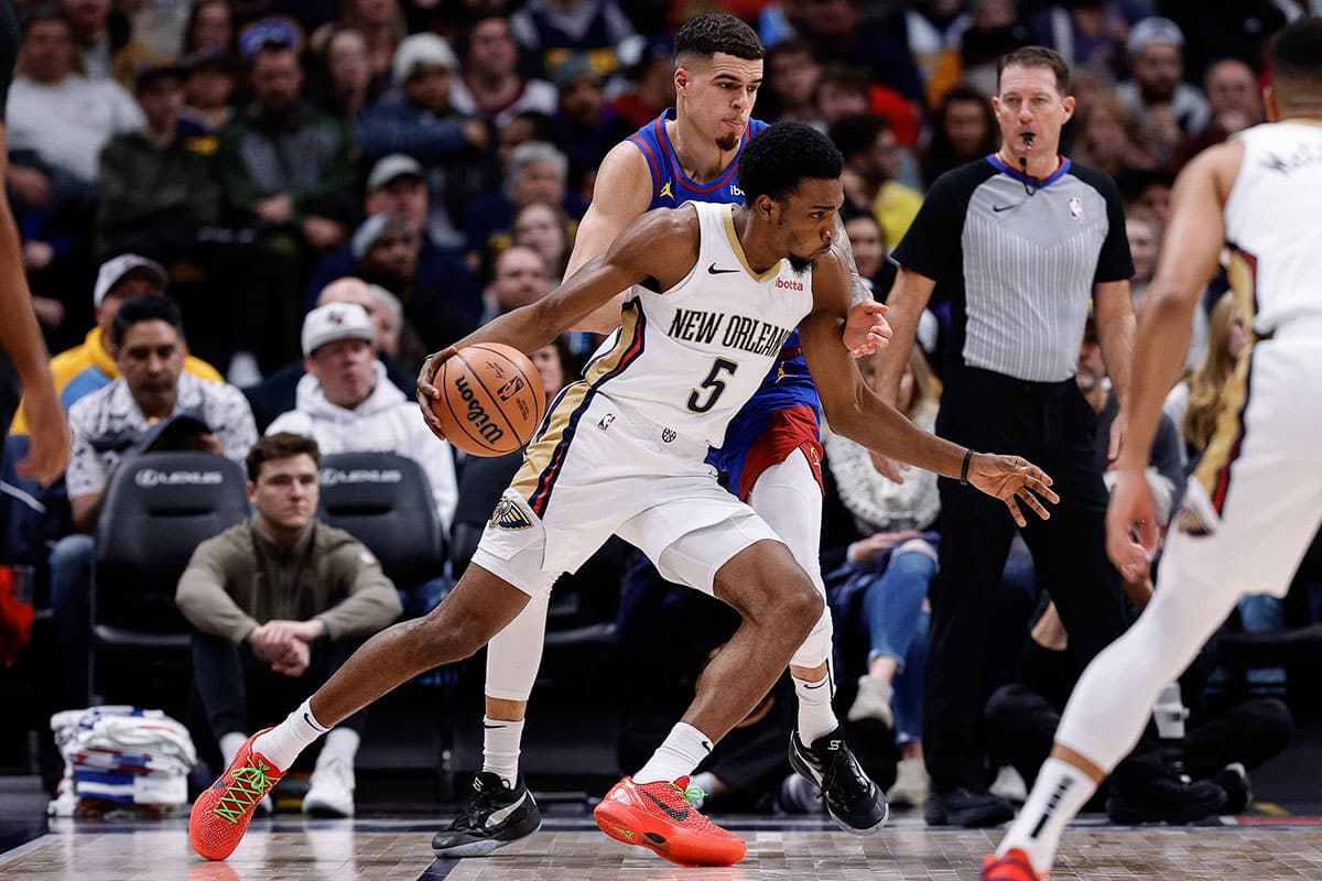 New Orleans Pelicans forward Herb Jones (5) controls the ball ahead of Denver Nuggets forward Michael Porter Jr. (1) in the third quarter at Ball Arena.