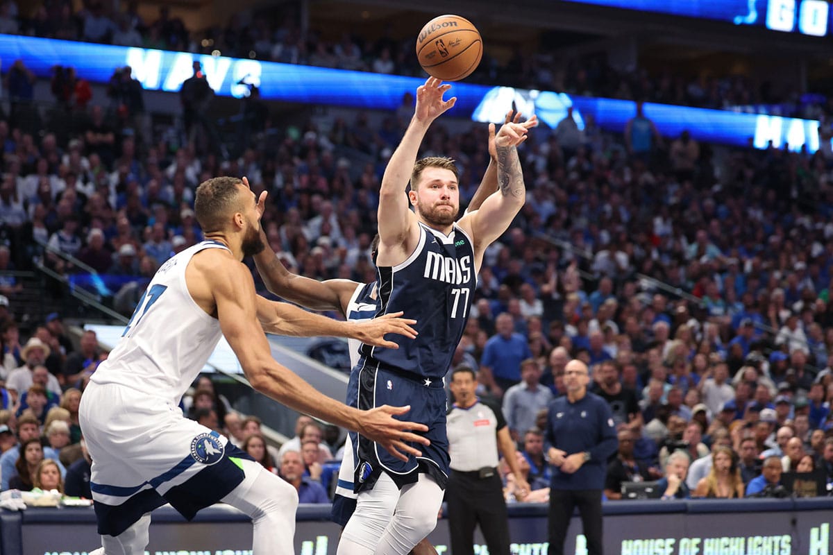 Dallas Mavericks guard Luka Doncic (77) passes the ball as Minnesota Timberwolves center Rudy Gobert (27) defends during the fourth quarter of game four of the western conference finals for the 2024 NBA playoffs at American Airlines Center.
