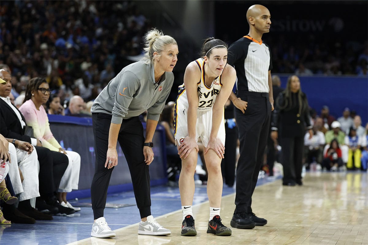 Indiana Fever head coach Christie Sides talks with guard Caitlin Clark (22) during the second half of a basketball game against the Chicago Sky at Wintrust Arena. 