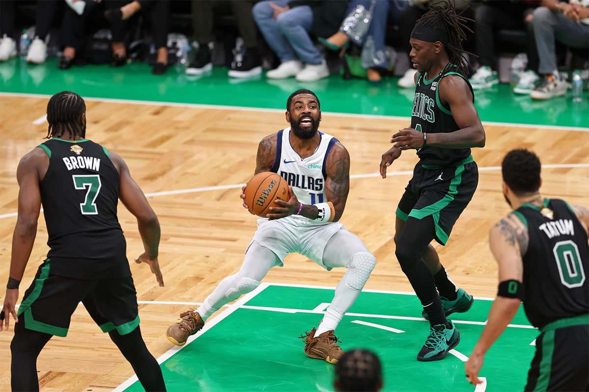 Dallas Mavericks guard Kyrie Irving (11) controls the ball against Boston Celtics guard Jrue Holiday (4) during the fourth quarter in game two of the 2024 NBA Finals at TD Garden.