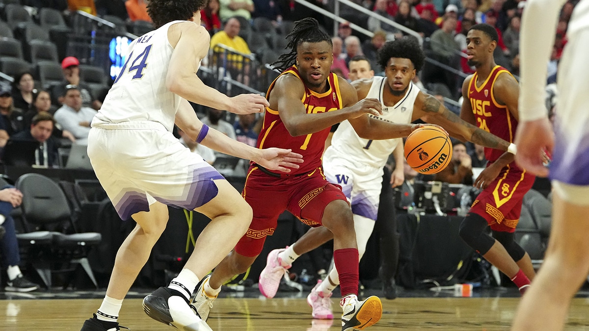 USC Trojans guard Isaiah Collier (1) dribbles between Washington Huskies center Braxton Meah (34) and forward Keion Brooks Jr. (1) during the second half at T-Mobile Arena.
