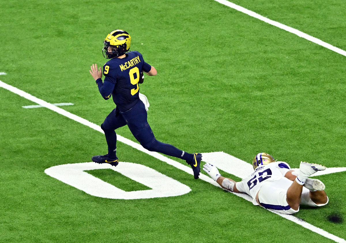 Michigan Wolverines quarterback J.J. McCarthy (9) escapes a tackle by Washington Huskies defensive end Voi Tunuufi (52) during the fourth quarter in the 2024 College Football Playoff national championship game at NRG Stadium.