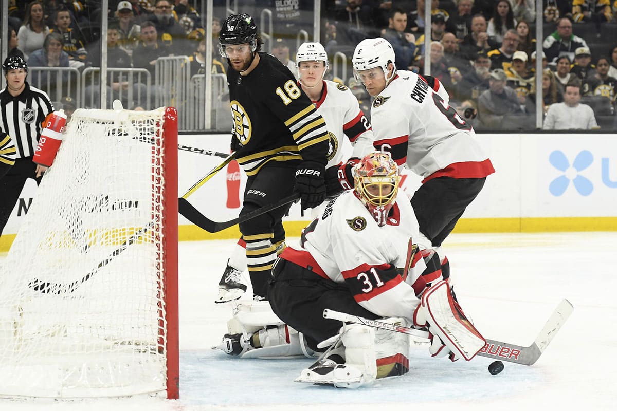 Ottawa Senators goaltender Anton Forsberg (31) makes a save in front of Boston Bruins center Pavel Zacha (18) and defenseman Jakob Chychrun (6) during the third period at TD Garden.