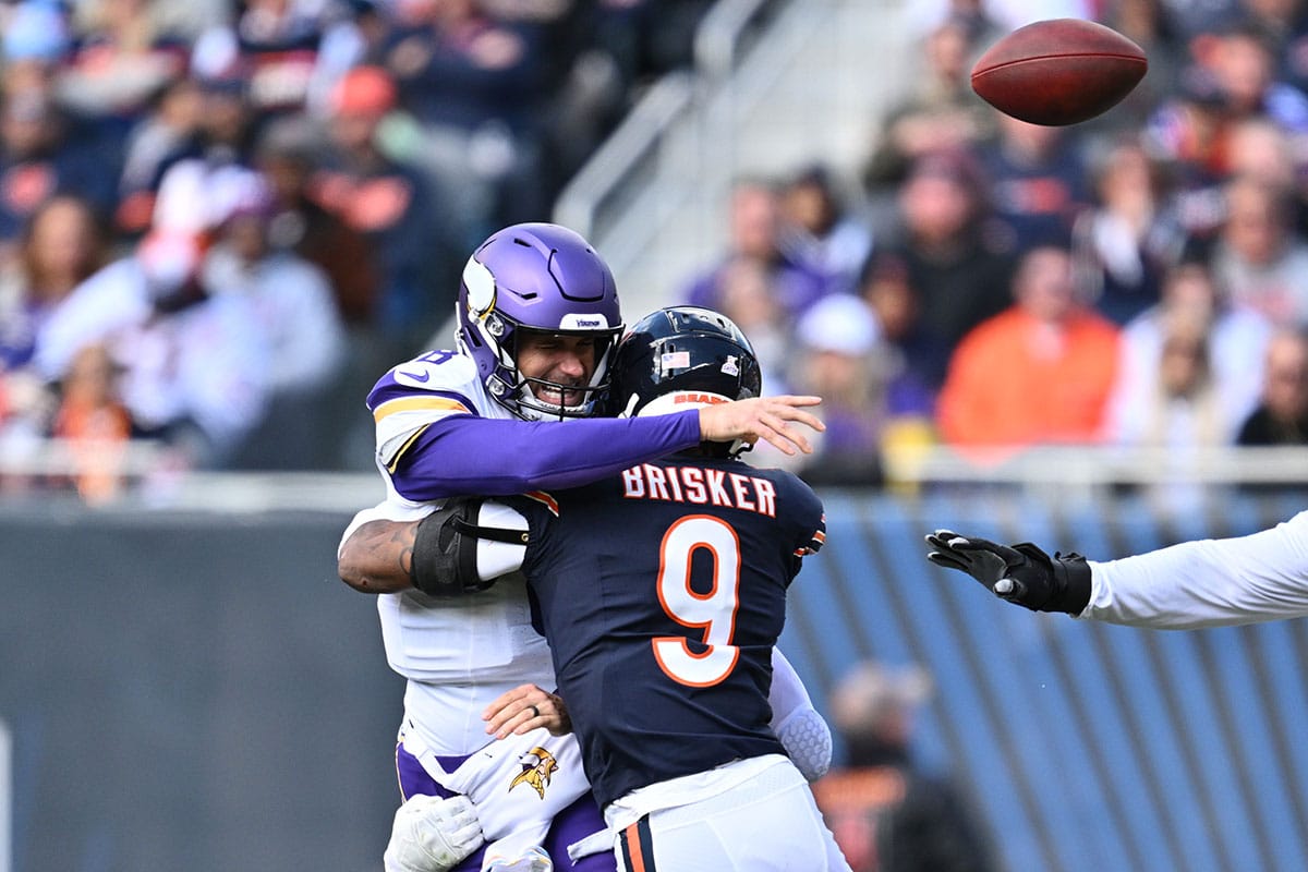 Minnesota Vikings quarterback Kirk Cousins (8) is hit by Chicago Bears defensive back Jaquan Brisker (9) causing a backwards pass for fumble in the first half at Soldier Field.