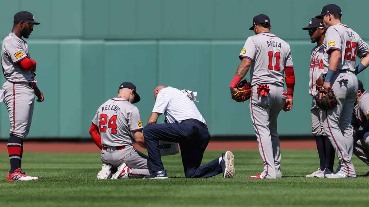 Atlanta Braves left fielder Jarred Kelenic (24) is looked at by trainers after making a diving catch during the sixth inning against the Boston Red Sox at Fenway Park.