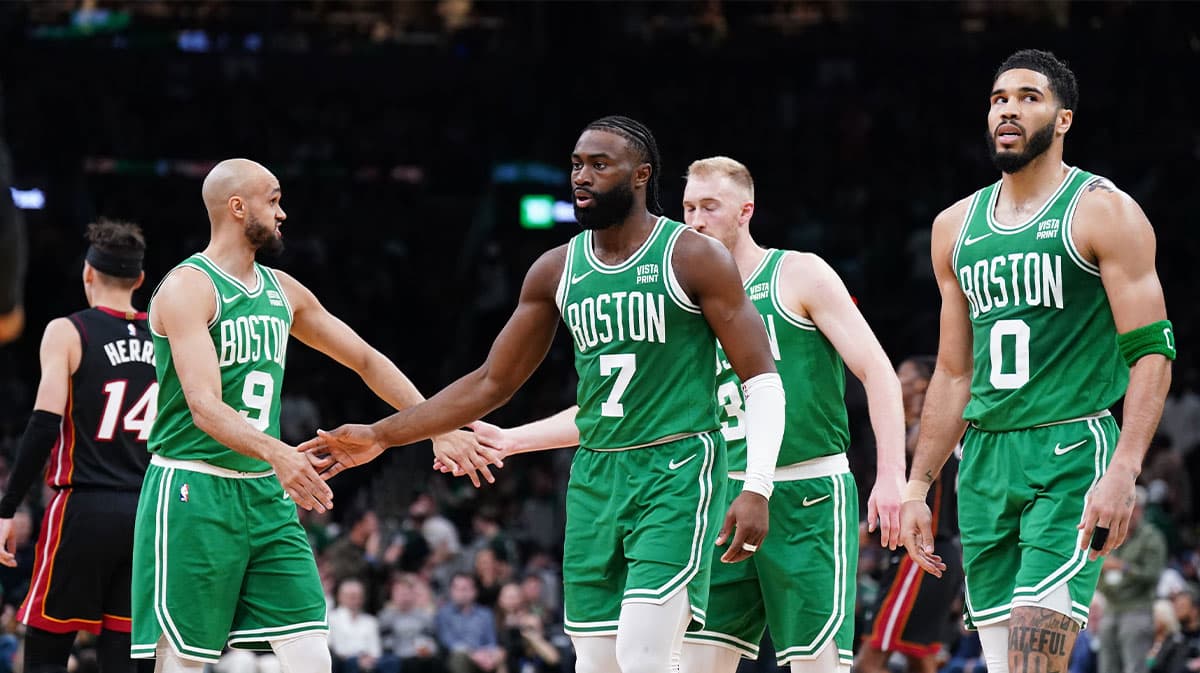 Boston Celtics guard Jaylen Brown (7), forward Jayson Tatum (0), guard Derrick White (9) and forward Sam Hauser (30) walk to the bench during a timeout against the Miami Heat in the second quarter during game two of the first round for the 2024 NBA playoffs at TD Garden.