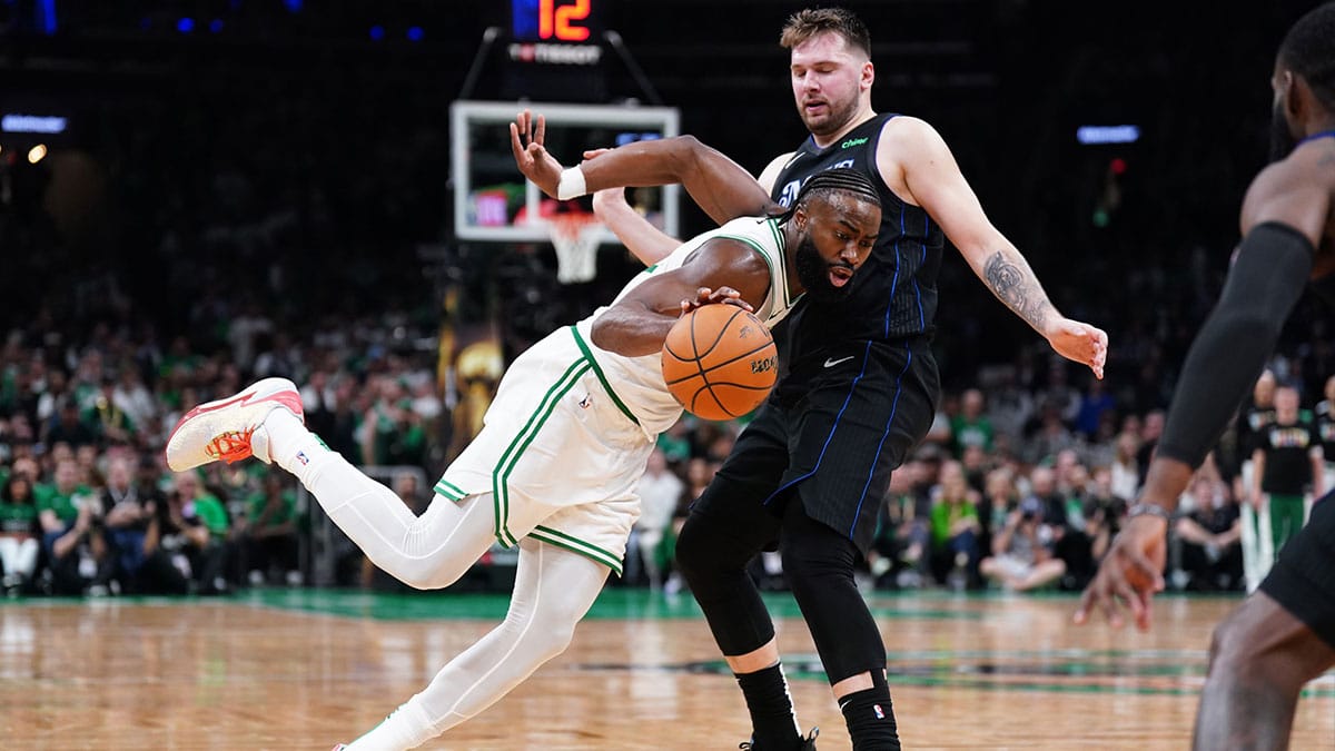 Boston Celtics guard Jaylen Brown (7) controls the ball against Dallas Mavericks guard Luka Doncic (77) in the third quarter during game one of the 2024 NBA Finals at TD Garden.