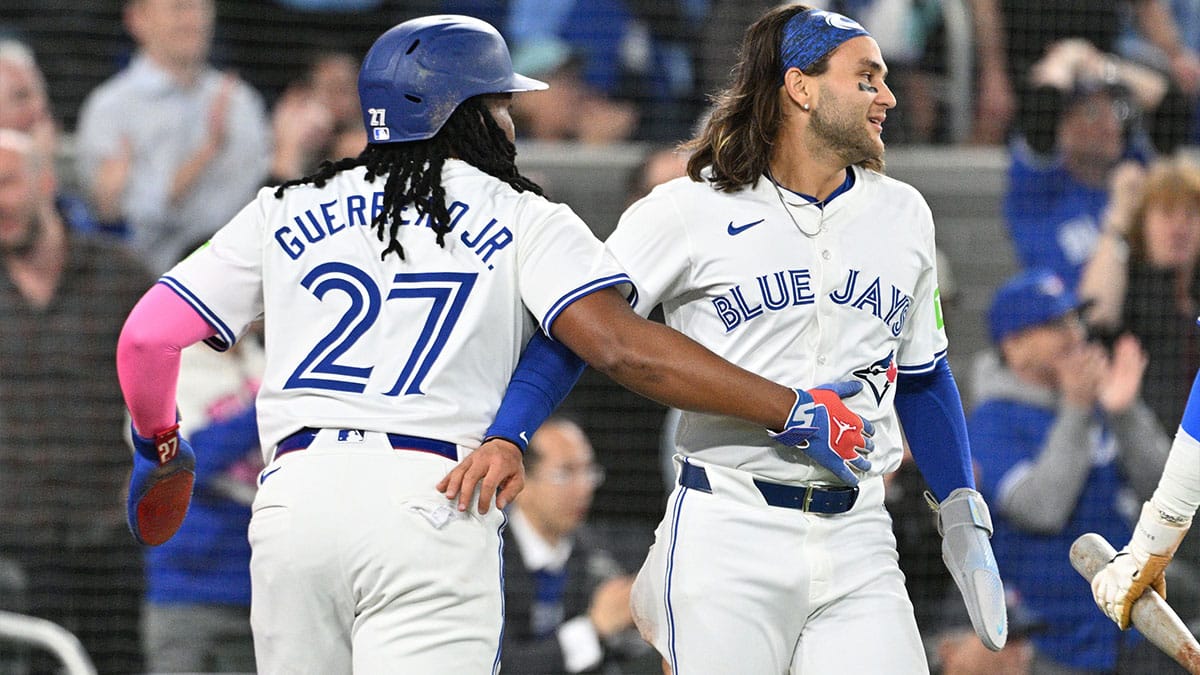 Toronto Blue Jays first baseman Vladimir Guerrero Jr. (27) and shortstop Bo Bichette (11) celebrate after scoring against the Seattle Mariners in the third inning at Rogers Centre.