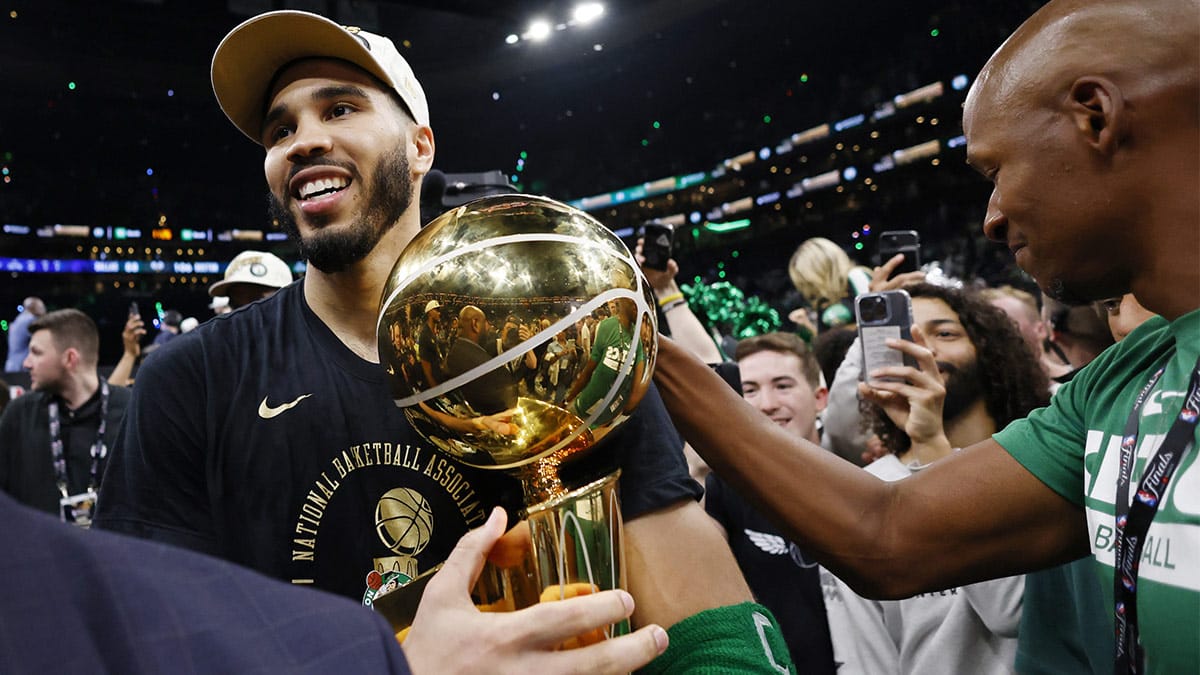 Jun 17, 2024; Boston, Massachusetts, USA; Boston Celtics forward Jayson Tatum (0) is greeted by Ray Allen as he walks off the court with the trophy as he celebrates winning the 2024 NBA Finals against the Dallas Mavericks at TD Garden.