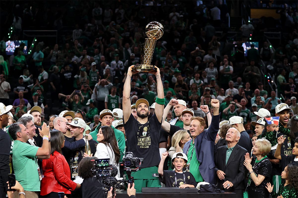 Boston Celtics forward Jayson Tatum (0) lifts the trophy after winning the 2024 NBA Finals against the Dallas Mavericks at TD Garden.