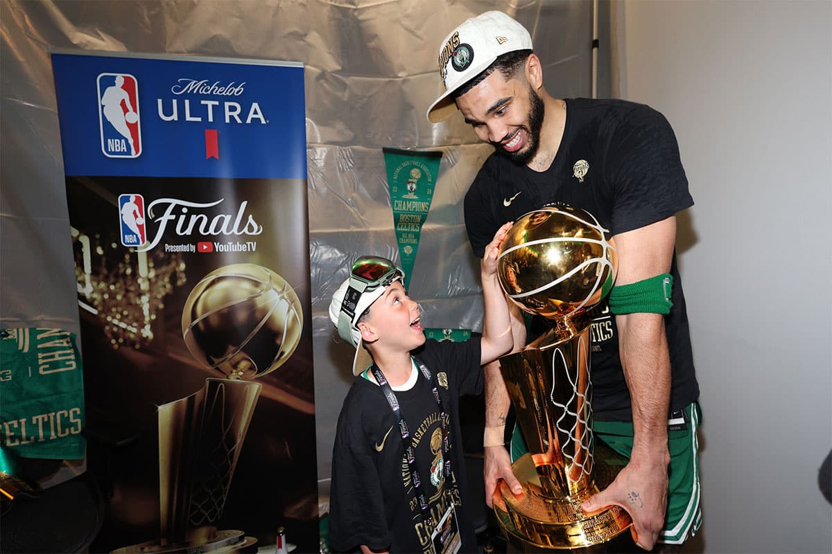 Boston Celtics forward Jayson Tatum (0) holds the Larry O’Brien Championship Trophy with his son after Boston's 106-88 win against the Dallas Mavericks after game five of the 2024 NBA Finals at TD Garden.
