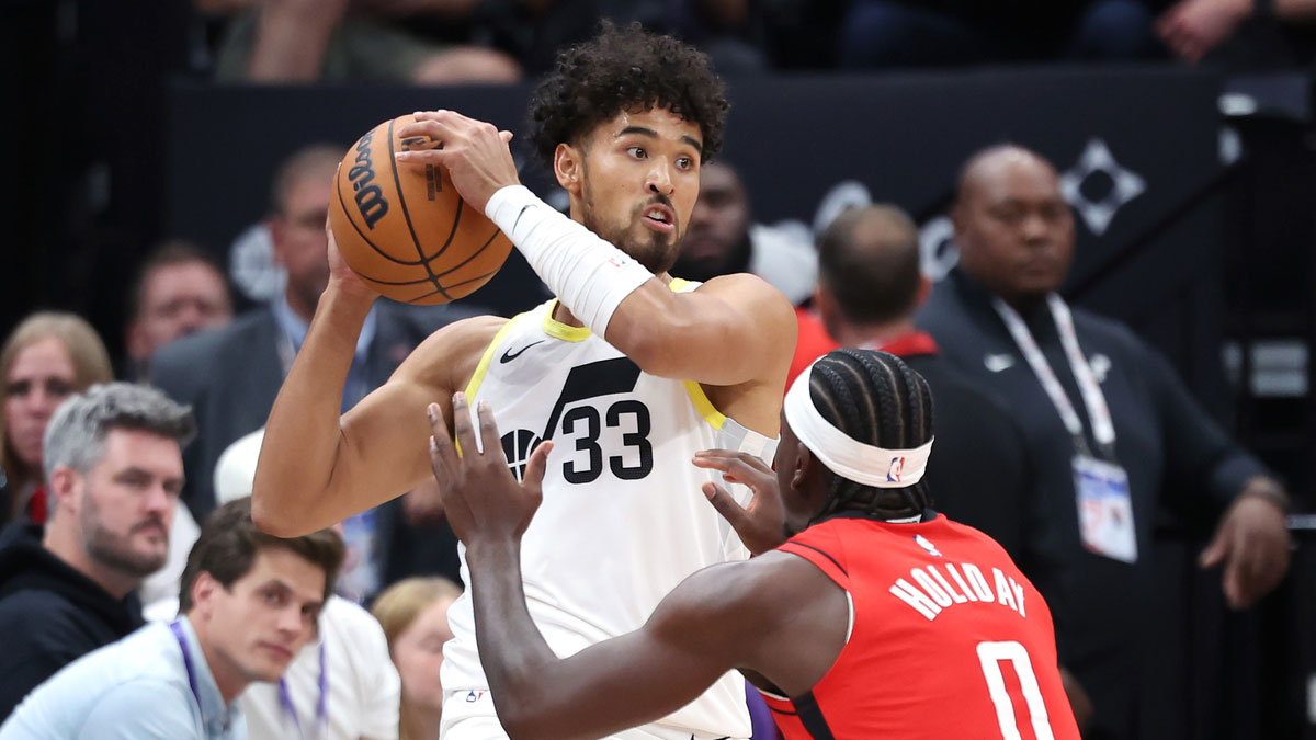 Utah Jazz guard Johnny Juzang (33) holds the ball away from Houston Rockets guard Aaron Holiday (0) during the fourth quarter at Delta Center.