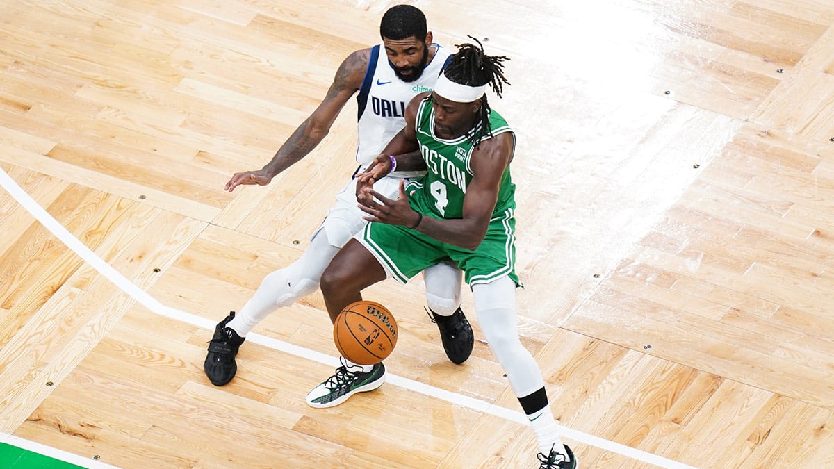 Boston Celtics guard Jrue Holiday (4) and Dallas Mavericks guard Kyrie Irving (11) fight for control in the second half during game five of the 2024 NBA Finals at TD Garden.