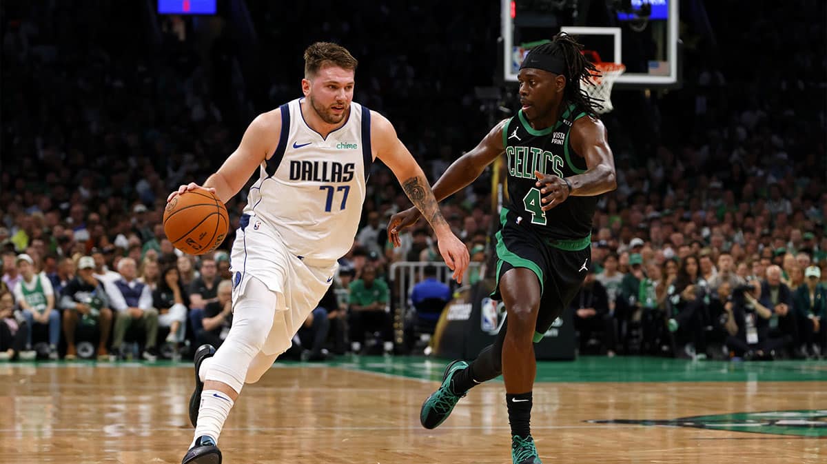 Dallas Mavericks guard Luka Doncic (77) dribbles the ball against Boston Celtics guard Jrue Holiday (4) during the first quarter in game two of the 2024 NBA Finals at TD Garden.