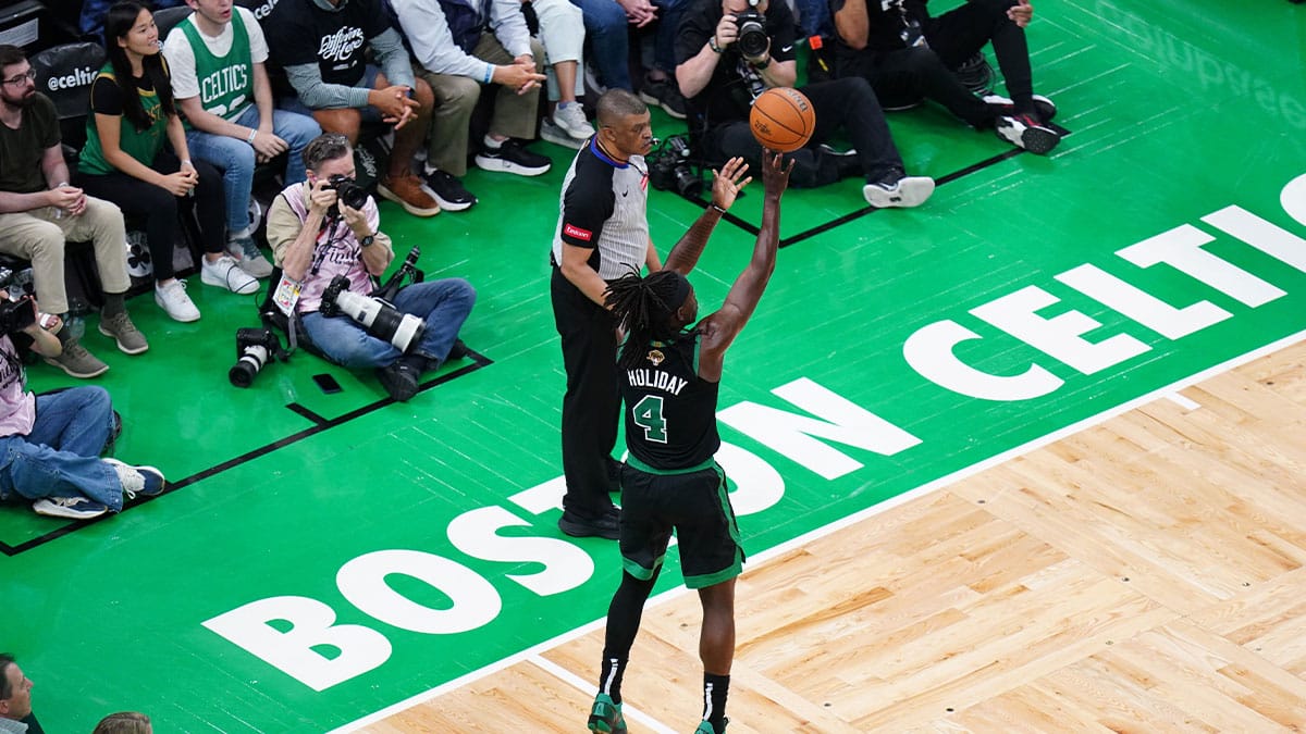 Boston Celtics guard Jrue Holiday (4) shoots a three point shot against the Dallas Mavericks in the second quarter during game two of the 2024 NBA Finals at TD Garden.