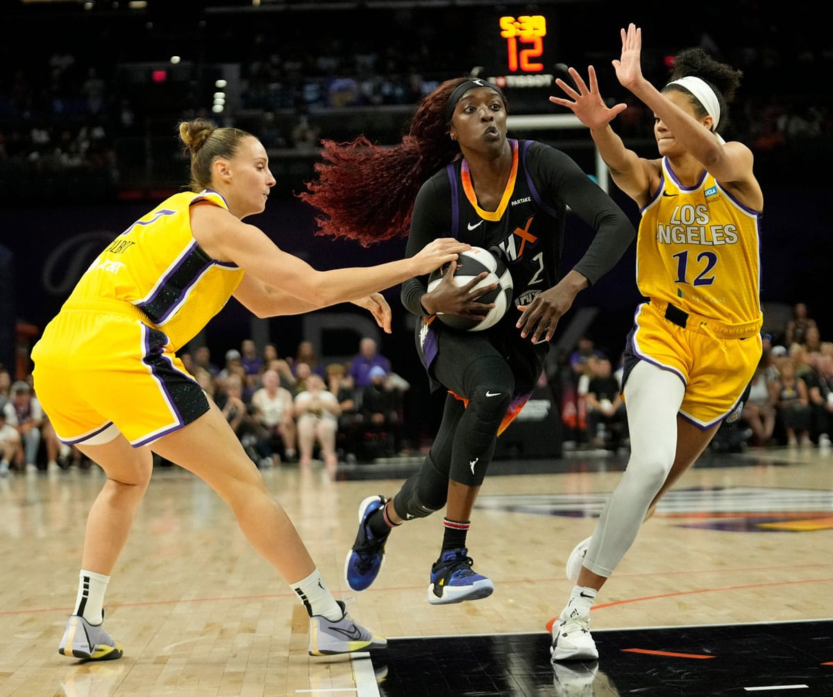Phoenix Mercury guard Kahleah Copper (2) drives between Los Angeles Sparks forward Stephanie Talbot (7) and guard Rae Burrell (12) during the second quarter.