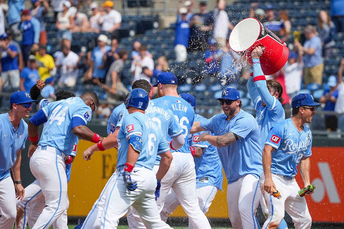 Kansas City Royals second baseman Nick Loftin (12) is doused by shortstop Bobby Witt Jr. (7) after hitting a walk off one-run sacrifice against the San Diego Padres in the ninth inning at Kauffman Stadium.